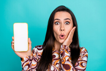 Wall Mural - Photo of excited lovely girl wear print shirt showing modern device empty space isolated turquoise color background