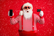 © deagreez - Portrait of his he handsome amazed stunned bearded fat overweight Santa holding in hands gadget bank card order app shopping service sale isolated bright vivid shine vibrant red color background
