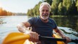 © peerawat - A man in his 70s kayaking on a serene lake, enjoying the calmness of nature and physical activity