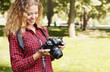 © Prostock-studio - Young female student taking photos in the park with camera. Photography classes, education and remote working concept, copy space, closeup