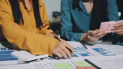 UX developer and ui designer brainstorming about mobile app interface wireframe design with customer breif and color code. business working