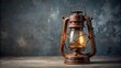 © nittiya - Old vintage rusty kerosene lamp on gray background. Glass oil storm lantern