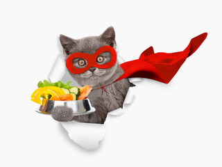 Aufkleber - Cute kitten wearing superhero costume looking through the hole in white paper and holding bowl of vegetables