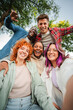 © Jose Calsina - Group of happy teenagers smiling and having fun outdoors, enjoying friendship and diversity while taking a selfie together in a park on a bright sunny day. Young friends smiling and laughing