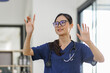 © David - Portrait of young asian attractive female doctor or nurse smiling and standing in hospital