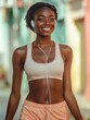 © Johannes - Young African woman in a tanktop and shorts smiling and listening to music on earphones while walking to yoga class