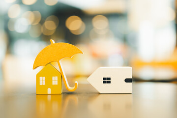 Wall Mural - Two house models, the first one is an umbrella, which is like a house with insurance, and the other one is a fallen house, which is like a house that is not insured in case of  an accident.