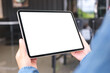 © Farknot Architect - Mockup image of a woman holding digital tablet with blank desktop screen in cafe