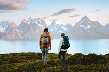 Wall Mural - couple enjoying mountains landscape in norway friends man and woman hiking with backpack, active vac