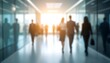 © Jittiwan - Blurred workplace background with businesspeople walking along modern office building hallway in sunlight day