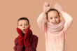 © Pixel-Shot - Cute little happy children in warm winter clothes having fun on brown background