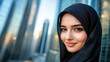 © Titon - Beautiful Emirati woman wearing black hijab, against cityscape background with skyscrapers