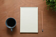 © Prathankarnpap - Blank notepad, pencil and a cup of coffee on wooden desk for starting a productive day of writing or planning