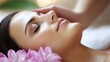 © Thuntaree - Relaxing Spa Treatment for a Woman Surrounded by Pink Flowers