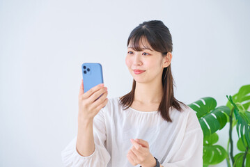 Poster - スマートフォンの画面を見る若い女性