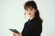 © Salander Studio - young businesswoman in a black suit holding a tablet - studio portrait on white background