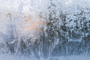 Frosty pattern on the window blue background. Frozen window glass.