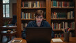 © Krasavina Alena - Focused young man studying on laptop in quiet library