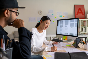 Wall Mural - ux ui designers discussing and brainstorming on wireframes for a website and mobile app prototype, i