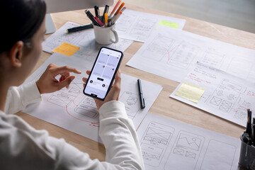 ux ui designer testing prototype on a phone, discussing and brainstorming on wireframes for a websit