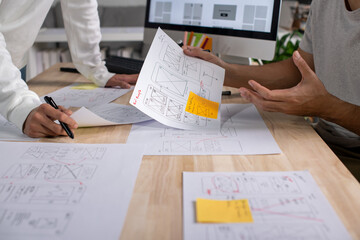Wall Mural - ux ui designers discussing and brainstorming on wireframes for a website and mobile app prototype, i