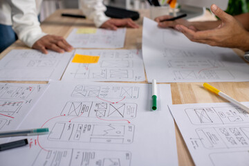 Wall Mural - ux ui designers discussing and brainstorming on wireframes for a website and mobile app prototype, i