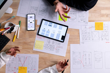 Wall Mural - ux ui designers discussing and brainstorming on wireframes for a website and mobile app prototype, i