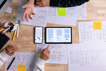 Wall Mural - ux ui designers discussing and brainstorming on wireframes for a website and mobile app prototype, i