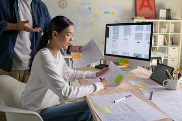 Wall Mural - ux ui designers discussing and brainstorming on wireframes for a website and mobile app prototype, i