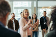 © Jacob Lund - Confident female speaker leading a training session with engaged employees in a modern office environment, promoting professional growth and team building