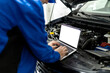 © zphoto83 - Mechanic using blank screen laptop to diagnose car issues in an auto repair shop during daylight hours