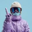 © sakuratanaka - A person wearing a purple ski jacket, gloves, and goggles points their finger.