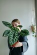 © Helle - woman holding plant holding the plant in focus