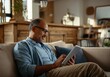 © Alexandra - Mature african male relaxing with tablet in cozy living room setting