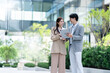 © Yingyaipumi - two Asian business people walking city urban street at business office center.Young business corporate team meeting in a business park.Leadership,coaching and group of people Discuss meeting