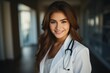 © larisikstefania - Smiling female doctor in white coat with stethoscope, exuding professionalism in hospital setting