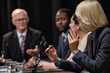 © Seventyfour - Rear view of female official speaking into microphone asking politician question during political debate or press conference meeting room, copy space
