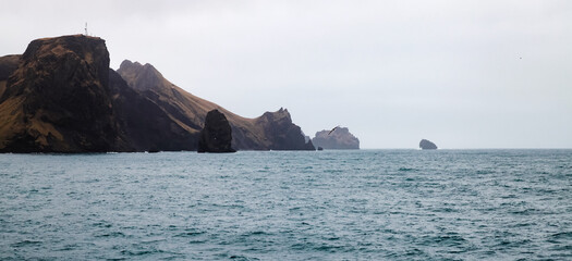 Wall Mural - Vestmannaeyjar island is under gray dramatic sky, seaside view