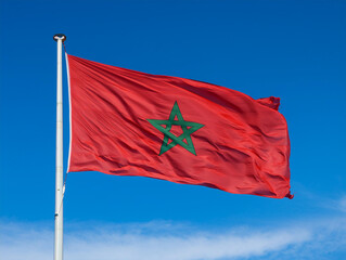 Close-up of the Moroccan flag waving in the wind with blue sky in the background