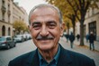 © ThomasLENNE - Close portrait of a smiling senior Azerbaijani man looking at the camera, Azerbaijani city outdoors  blurred background
