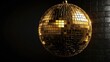 © claudunia - Golden disco mirror ball with shiny tiles on a black background.