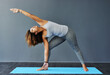 © peopleimages.com - Woman, pilates and stretching for fitness in home studio, morning meditation and flexible activity. Female person, yoga challenge and holistic healing for mindfulness, peace exercise and wellness