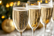 © Irina Kozel - Minimalistic photo of champagne glasses filled with bubbly champagne, set against a backdrop of golden holiday decorations