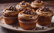 © Morten - Plate with five cupcakes with chocolate chips on top. The cupcakes are brown and have chocolate frosting