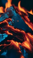 Wall Mural - close-up view of a dark surface with vivid burn effects showing bright orange and red flames licking