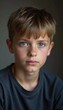 © Julija - A young boy from Russia gazes directly at the viewer with captivating grey eyes. His tousled hair frames his face, and he wears a cozy casual clothes. Rosy cheeks, piercing serious look. Generative AI