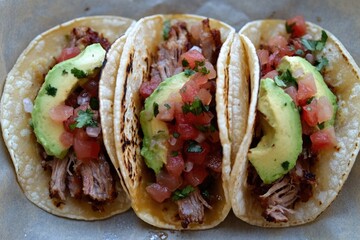 Poster - A plate of three tacos filled with meat, tomatoes, and avocado