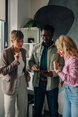 Business people collaborating on digital tablet in modern office