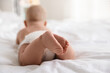 © New Africa - Cute little baby in diaper on bed indoors, selective focus. Space for text