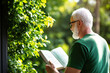 © Darat - Elderly man reading self help book surrounded by greenery